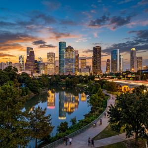 Houston skyline at sunset with tall buildings reflecting in water